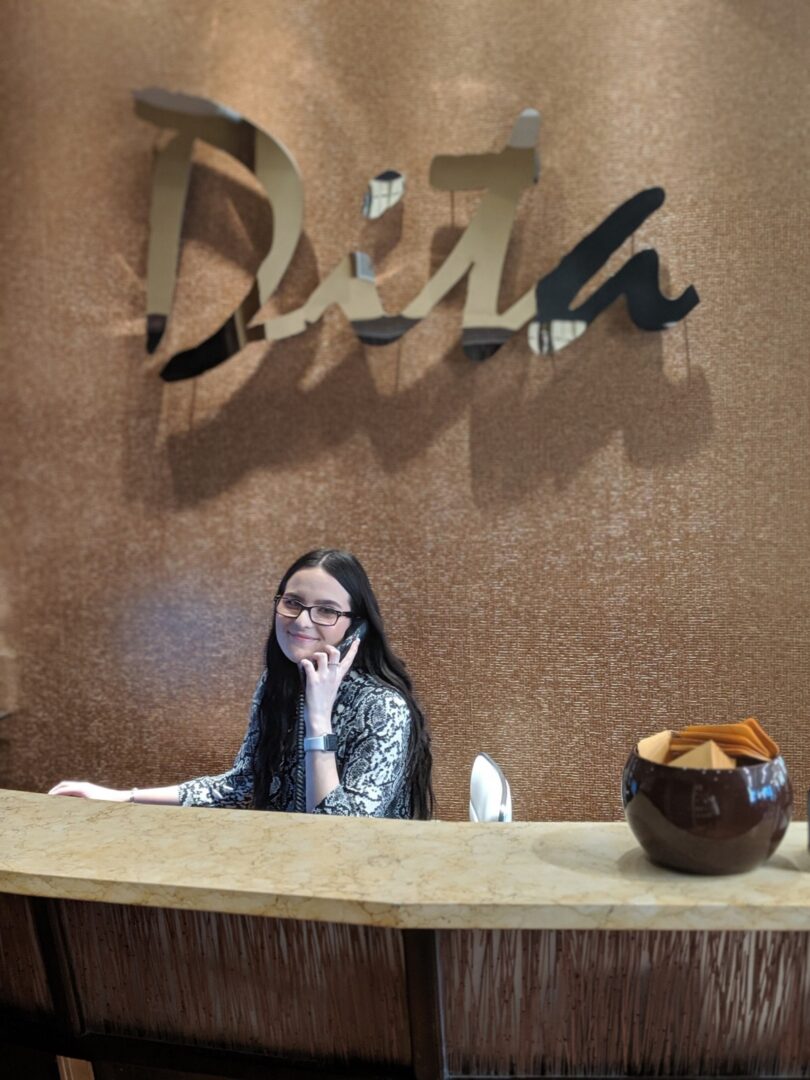 A woman sitting at the counter of a hotel lobby.