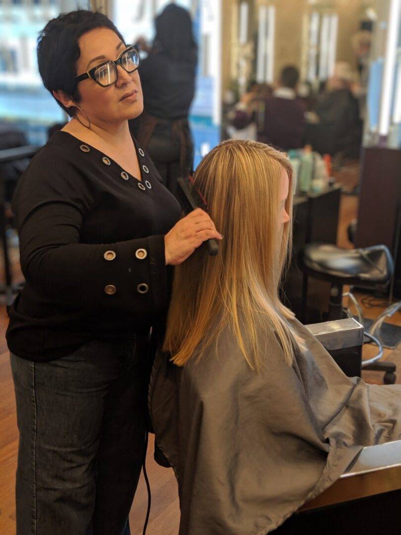 A woman is getting her hair cut at the salon