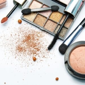 A table topped with makeup and some brushes.