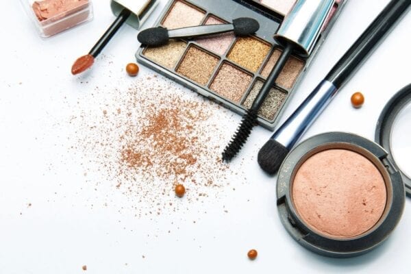 A table topped with makeup and some brushes.