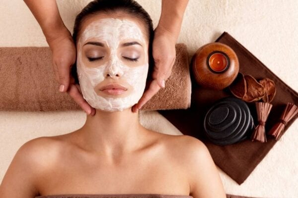 A woman getting her face washed with clay