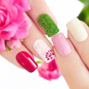 A woman is holding her nails with different designs on them.