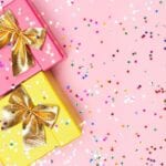 Two pink and yellow gift boxes with gold bows.