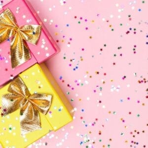 Two pink and yellow gift boxes with gold bows.