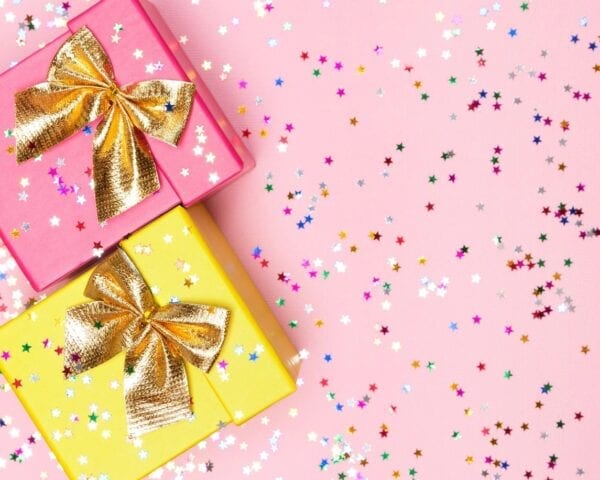 Two pink and yellow gift boxes with gold bows.